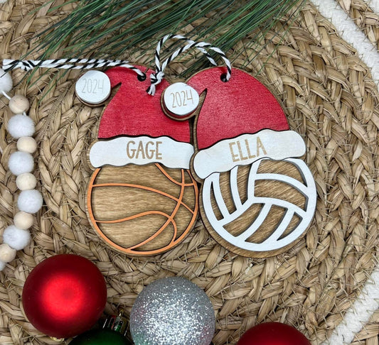 Decorative ornament with 'Gage' and 'Ella' on a woven surface with Christmas balls.