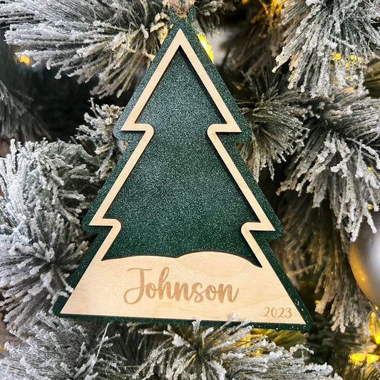Decorative Christmas tree ornament with 'Johnson' and '2023' on a Christmas tree background