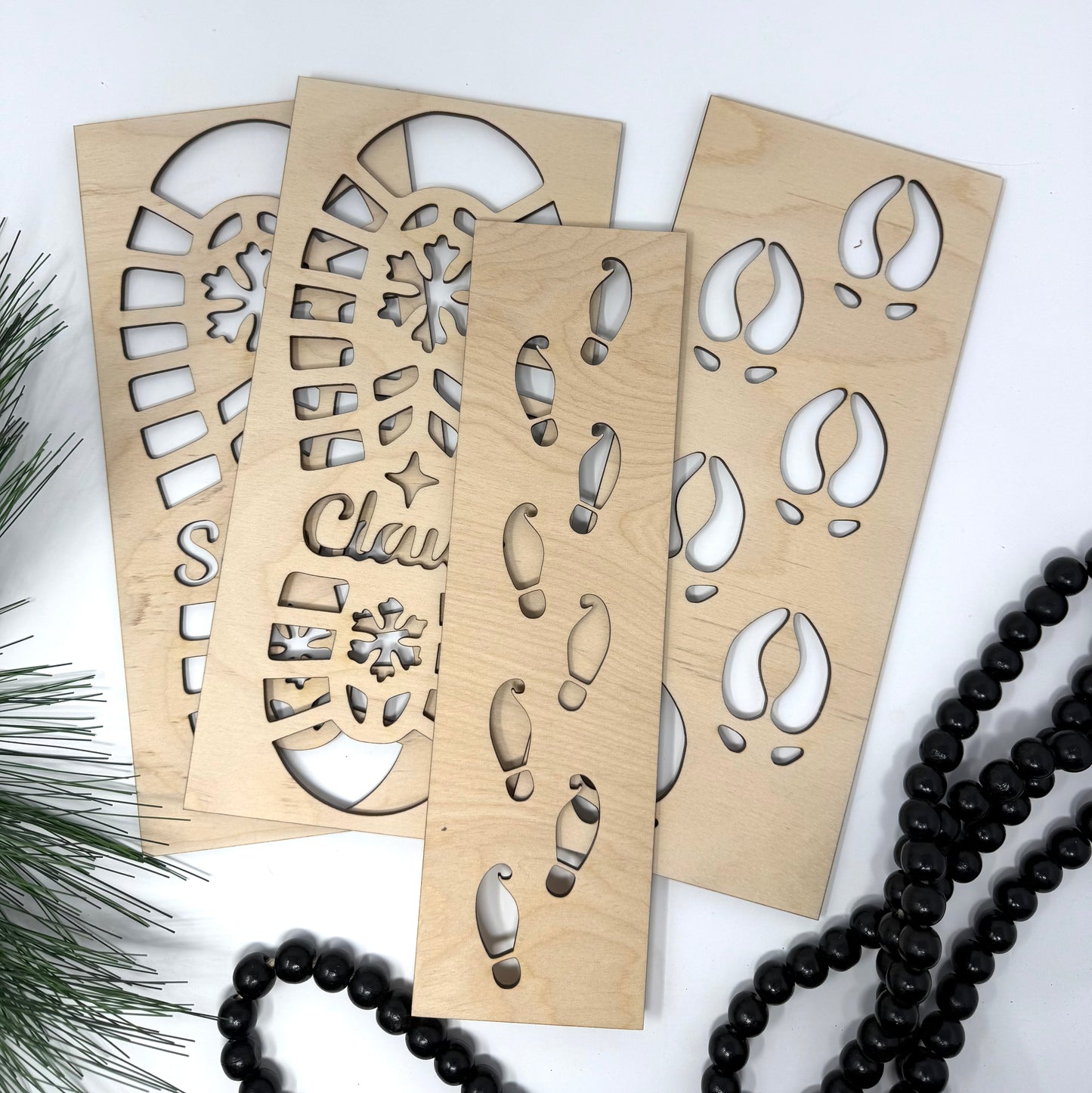 Wooden stencils with cut-out patterns on a white background