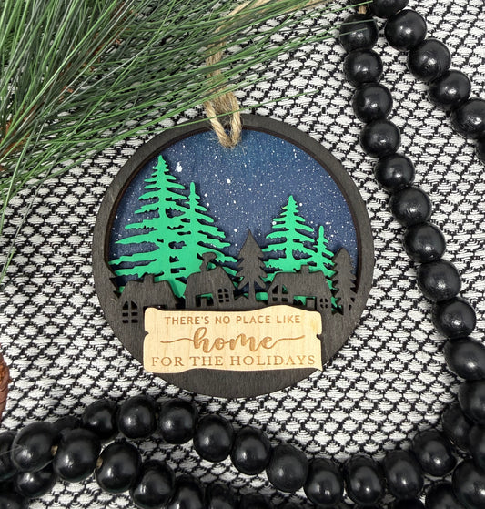 Decorative ornament with a forest scene and text, surrounded by black beads and greenery.